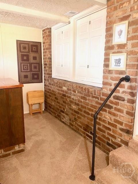 2006 Cokesbury Dr, Savannah, GA 31406 - hallway with carpet flooring, brick wall, and a textured ceiling