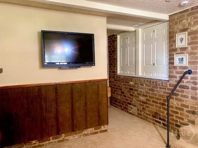 2006 Cokesbury Dr, Savannah, GA 31406 - interior space featuring carpet, a textured ceiling, brick wall, wainscoting, and beam ceiling