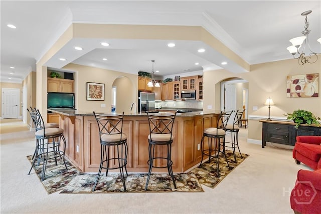 204 River Oaks Dr, Richmond Hill, GA 31324 - kitchen with appliances with stainless steel finishes, light carpet, arched walkways, a chandelier, and recessed lighting