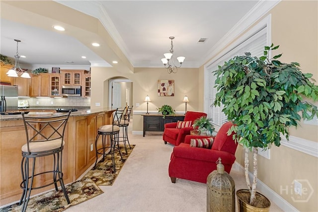 204 River Oaks Dr, Richmond Hill, GA 31324 - kitchen featuring appliances with stainless steel finishes, a breakfast bar area, arched walkways, light carpet, and glass insert cabinets