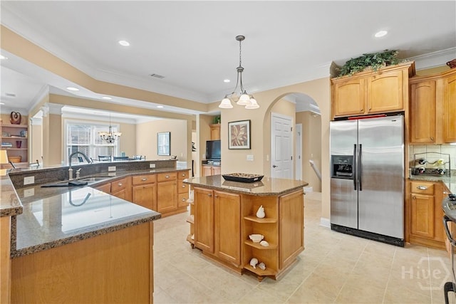 204 River Oaks Dr, Richmond Hill, GA 31324 - kitchen featuring stainless steel fridge, a large island with sink, a sink, crown molding, and arched walkways