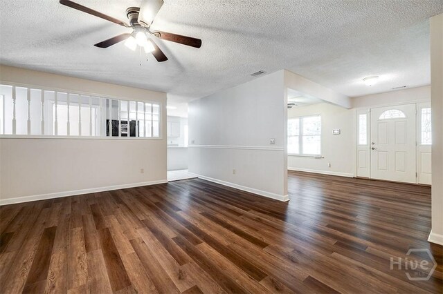 1282 Long Bridge Rd, Rincon, GA 31326 - unfurnished living room featuring ceiling fan, a textured ceiling, dark wood-style flooring, and baseboards