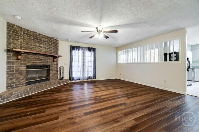 1282 Long Bridge Rd, Rincon, GA 31326 - unfurnished living room featuring a ceiling fan, wood finished floors, a textured ceiling, baseboards, and a fireplace