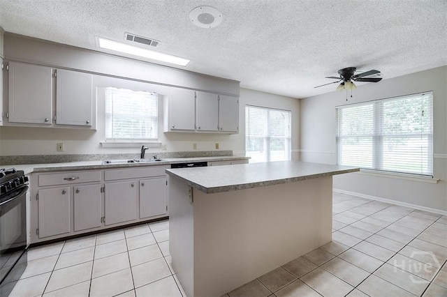 1282 Long Bridge Rd, Rincon, GA 31326 - kitchen with a sink, black range with gas cooktop, healthy amount of natural light, light tile patterned floors, and a textured ceiling