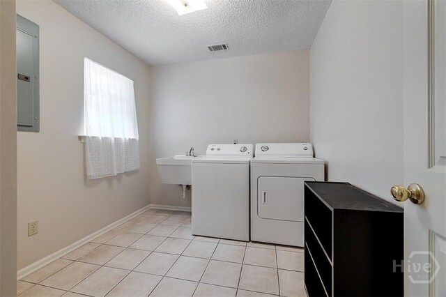 1282 Long Bridge Rd, Rincon, GA 31326 - washroom with washer and dryer, a textured ceiling, electric panel, light tile patterned floors, and baseboards