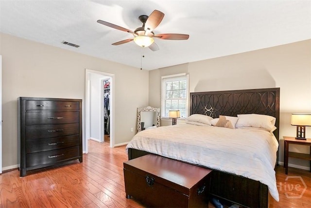 1409 Bellview Dr, Savannah, GA 31406 - bedroom with a walk in closet, baseboards, light wood-type flooring, a ceiling fan, and a closet