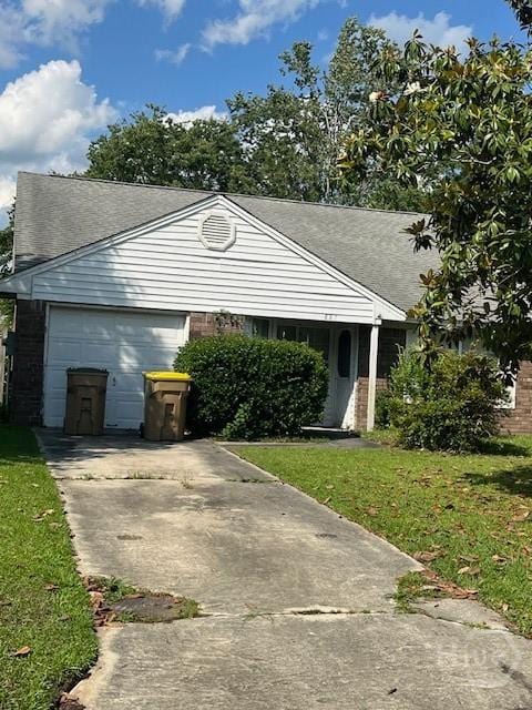 887 Piercefield Dr, Richmond Hill, GA 31324 - view of front of house featuring concrete driveway, a front lawn, an attached garage, and brick siding