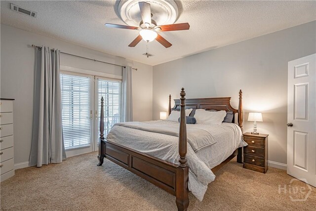 bedroom featuring light colored carpet, a textured ceiling, access to outside, ceiling fan, and baseboards