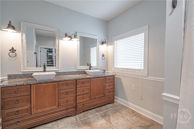 bathroom with tile patterned flooring, double vanity, and baseboards