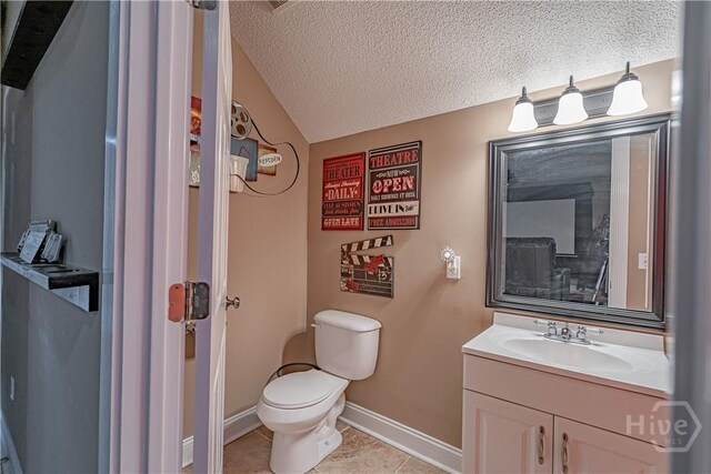 bathroom with vanity, toilet, tile patterned floors, a textured ceiling, and vaulted ceiling