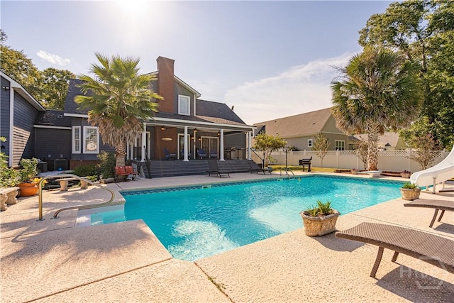 view of swimming pool with a water slide and a patio