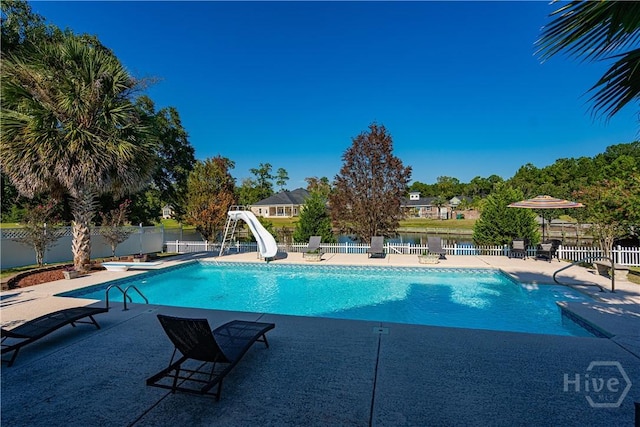 view of swimming pool featuring a fenced backyard, a water slide, and a patio