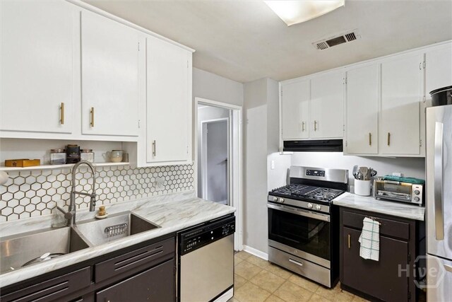 103 Pine Valley Rd, Savannah, GA 31404 - kitchen with appliances with stainless steel finishes, a sink, under cabinet range hood, light countertops, and white cabinetry
