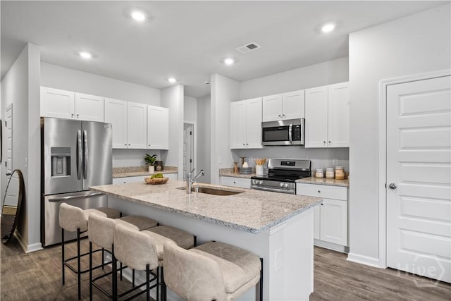 137 Crimson Ln, Savannah, GA 31302 - kitchen featuring stainless steel appliances, a sink, a kitchen island with sink, dark wood-style flooring, and a breakfast bar