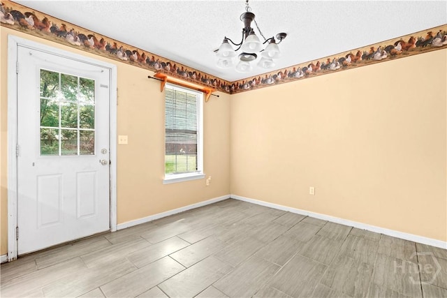 115 Ashley Dr, Guyton, GA 31312 - unfurnished dining area featuring a chandelier, baseboards, a textured ceiling, and wood tiled floors