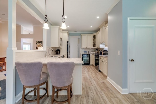354 Brown Thrush Rd, Savannah, GA 31419 - kitchen featuring a sink, appliances with stainless steel finishes, beverage cooler, a breakfast bar, and a peninsula