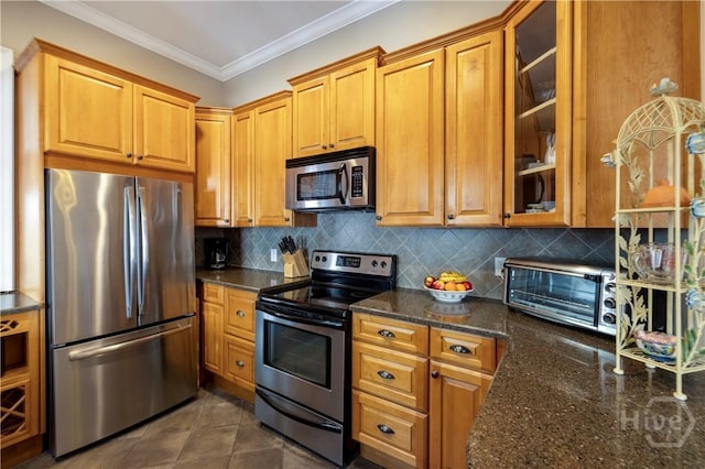 120 Brady St, Savannah, GA 31401 - kitchen featuring stainless steel appliances, crown molding, tasteful backsplash, glass insert cabinets, and dark stone counters