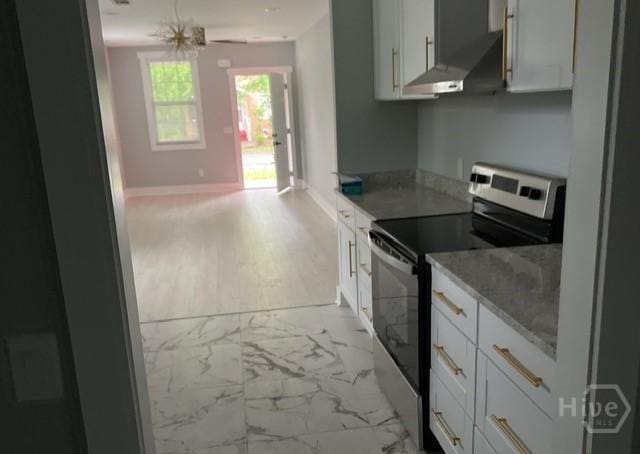 716 W 51st St, Savannah, GA 31405 - kitchen with stainless steel electric stove, range hood, white cabinetry, light stone counters, and light marble finish flooring