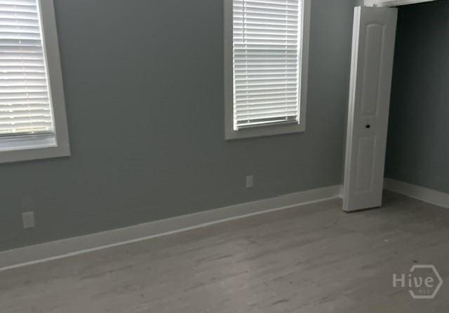 716 W 51st St, Savannah, GA 31405 - unfurnished bedroom with wood finished floors, baseboards, and a closet