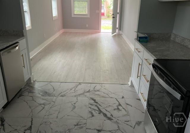 716 W 51st St, Savannah, GA 31405 - kitchen with stainless steel dishwasher, range with electric cooktop, white cabinetry, baseboards, and light countertops