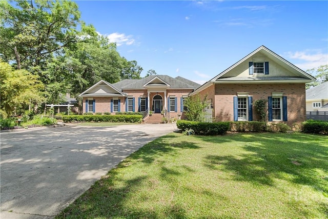 245 Montauk Dr, Richmond Hill, GA 31324 - greek revival house with brick siding, a front yard, and driveway