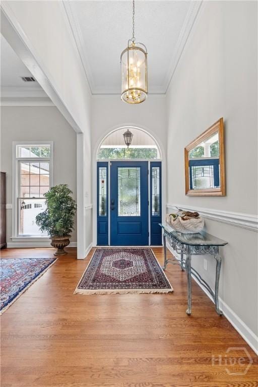 245 Montauk Dr, Richmond Hill, GA 31324 - foyer entrance featuring a chandelier, crown molding, wood finished floors, and baseboards