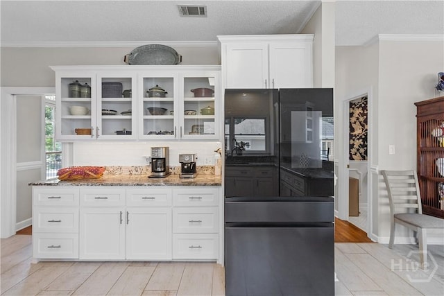 245 Montauk Dr, Richmond Hill, GA 31324 - kitchen featuring light stone counters, white cabinetry, smart refrigerator, glass insert cabinets, and ornamental molding