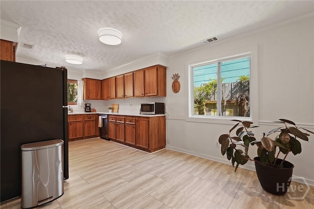 355 Riverview Dr, Savannah, GA 31404 - kitchen with stainless steel appliances, brown cabinetry, light countertops, a textured ceiling, and plenty of natural light