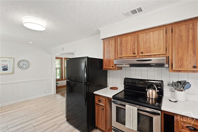 355 Riverview Dr, Savannah, GA 31404 - kitchen featuring stainless steel electric stove, under cabinet range hood, freestanding refrigerator, brown cabinets, and light countertops