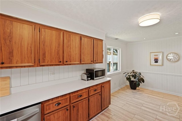 355 Riverview Dr, Savannah, GA 31404 - kitchen with stainless steel appliances, brown cabinetry, light countertops, ornamental molding, and baseboards