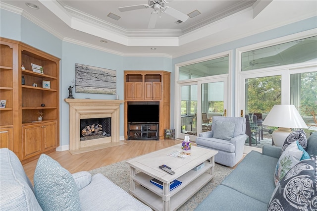 4 Longwater Ln, Savannah, GA 31411 - living area with a raised ceiling, light wood finished floors, ornamental molding, a fireplace, and a ceiling fan