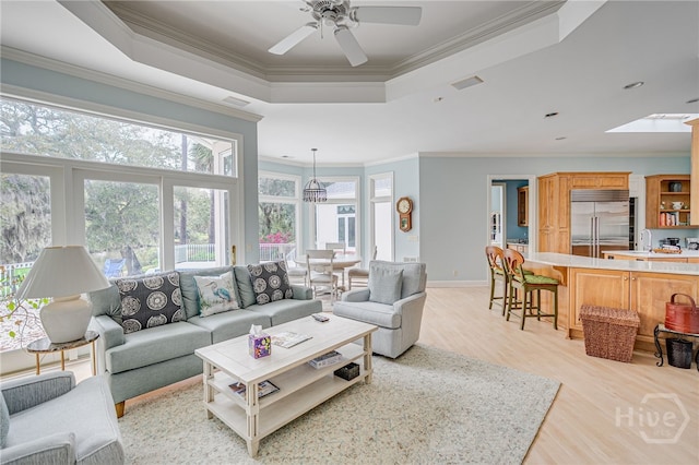 4 Longwater Ln, Savannah, GA 31411 - living area with crown molding, a raised ceiling, light wood-style floors, ceiling fan, and a skylight