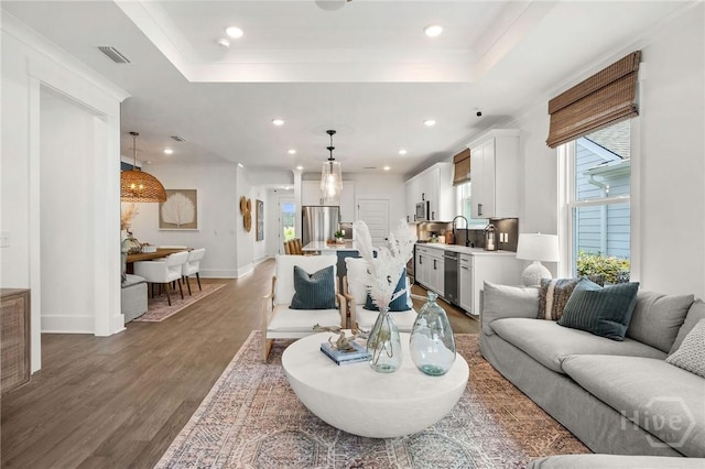 333 Birch Dr, Richmond Hill, GA 31324 - living area featuring wood finished floors, a tray ceiling, recessed lighting, and baseboards