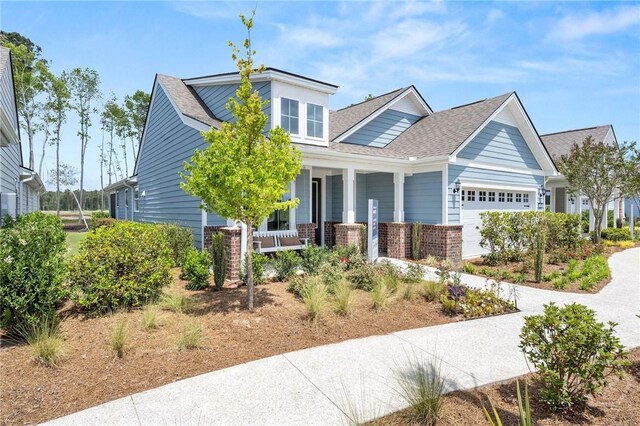 333 Birch Dr, Richmond Hill, GA 31324 - view of front of home with covered porch, a garage, brick siding, and roof with shingles