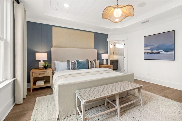 333 Birch Dr, Richmond Hill, GA 31324 - bedroom with a tray ceiling, wood finished floors, baseboards, and ensuite bath