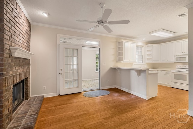 205 Meadowlark Cir, Savannah, GA 31419 - kitchen with white appliances, open shelves, light wood finished floors, a breakfast bar, and a textured ceiling