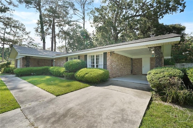 604 Windsor Rd, Savannah, GA 31419 - view of front of house with brick siding, concrete driveway, a front lawn, and a carport