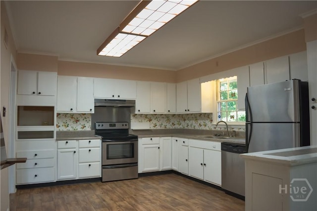 604 Windsor Rd, Savannah, GA 31419 - kitchen with stainless steel appliances, under cabinet range hood, ornamental molding, a sink, and white cabinetry