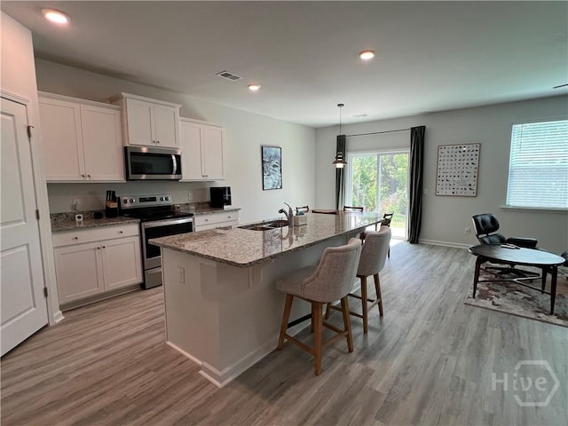 156 Kraft, Pooler, GA 31322 - kitchen with appliances with stainless steel finishes, a sink, light wood finished floors, light stone countertops, and white cabinets