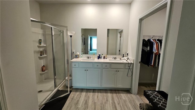 156 Kraft, Pooler, GA 31322 - full bathroom featuring a stall shower, wood finished floors, double vanity, a walk in closet, and a towering ceiling