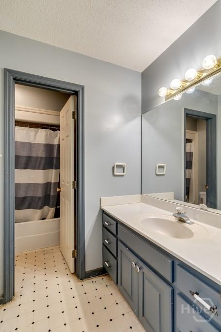 510 Mallory Rd, Reidsville, GA 30453 - full bath with tile patterned floors, vanity, a textured ceiling, and shower / bath combination with curtain