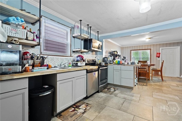 514 W 38th St, Savannah, GA 31415 - kitchen with stainless steel appliances, a sink, ornamental molding, a peninsula, and tasteful backsplash