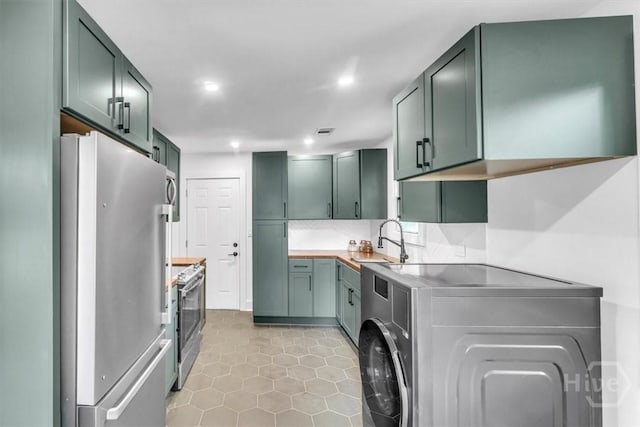 2501 Louisiana Ave, Savannah, GA 31404 - kitchen with appliances with stainless steel finishes, washer / dryer, a sink, recessed lighting, and light tile patterned floors