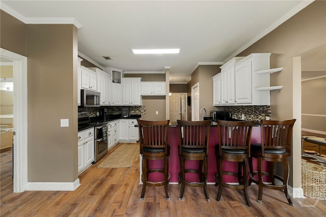 209 Saint James Walk, Guyton, GA 31312 - kitchen featuring appliances with stainless steel finishes, a peninsula, open shelves, dark countertops, and white cabinets