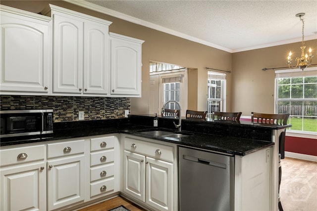 209 Saint James Walk, Guyton, GA 31312 - kitchen with dishwasher, a sink, a peninsula, white cabinets, and a chandelier