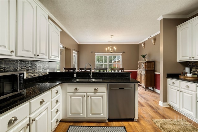 209 Saint James Walk, Guyton, GA 31312 - kitchen featuring stainless steel appliances, a sink, a peninsula, a chandelier, and white cabinetry
