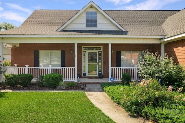209 Saint James Walk, Guyton, GA 31312 - view of front of property with brick siding, a porch, roof with shingles, and a front yard