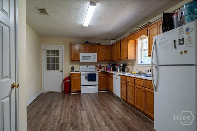 812 King Arthur Dr, Statesboro, GA 30458 - kitchen featuring white appliances, dark wood-type flooring, a textured ceiling, light countertops, and a sink
