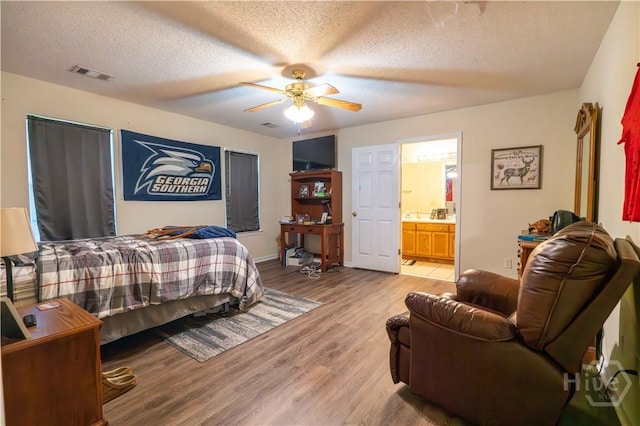 812 King Arthur Dr, Statesboro, GA 30458 - bedroom featuring light wood-type flooring, ensuite bath, a textured ceiling, and ceiling fan
