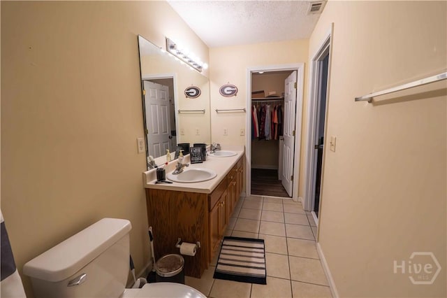 812 King Arthur Dr, Statesboro, GA 30458 - bathroom with toilet, tile patterned flooring, a textured ceiling, double vanity, and baseboards